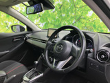 運転席まわりは前方を見渡しやすい配置で、座ったままメーターやセンターディスプレイを確認できます。シートの赤いアクセントが空間を引き締め、落ち着いて過ごせる印象です。