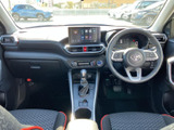 運転席から前方を見渡しやすいレイアウトで、メーターや中央の画面も視線を移しやすい位置にあります。シートは赤いアクセントが入り、日常の乗り降りにもなじむ空間です。