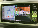 地図表示とテレビ画面を切り替えて使えるナビゲーションを装備。画面脇には音量調整用のダイヤルやメニュー類がまとまり、目的地設定や音源選びも視線を移しやすい配置です。